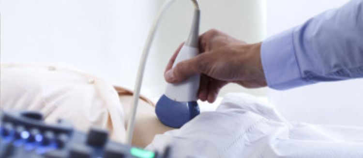 A doctor performs an ultrasound on a patients stomach