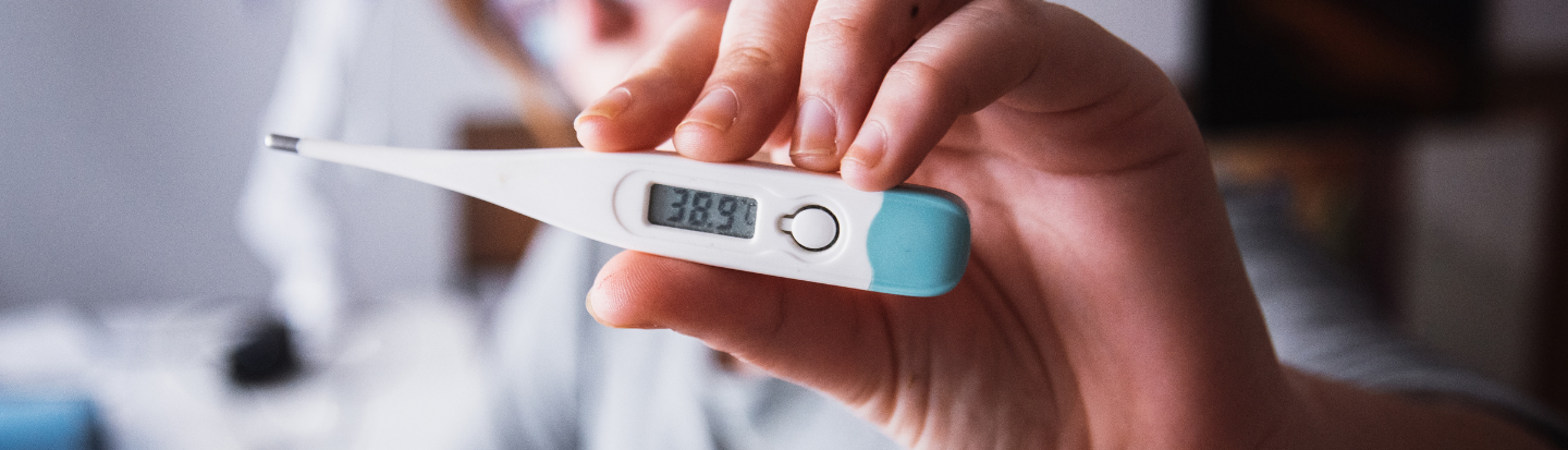 Stock photo of person holding up thermometer