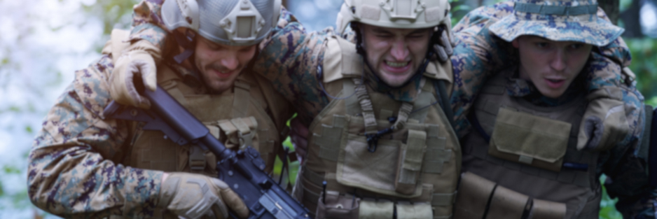 Stock photo of two soldiers carrying a wounded soldier