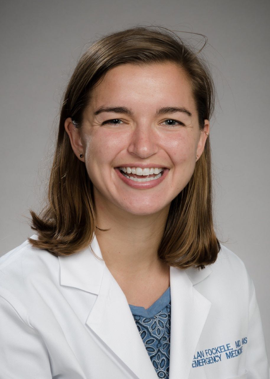 Dr. Callan Fockele's headshot in a white coat against a gray background