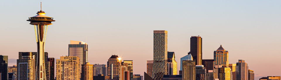 A view of the Seattle skyline at sunset with the Space Needle on display in the left corner of the photo.