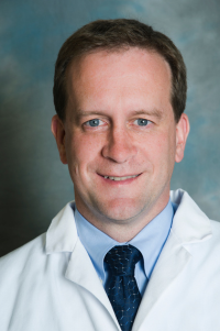 Headshot of Dr. Steve Mitchell in a white coat against a gray background