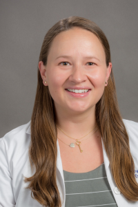 Headshot of Dr. Elle Sveum in white coat against gray background