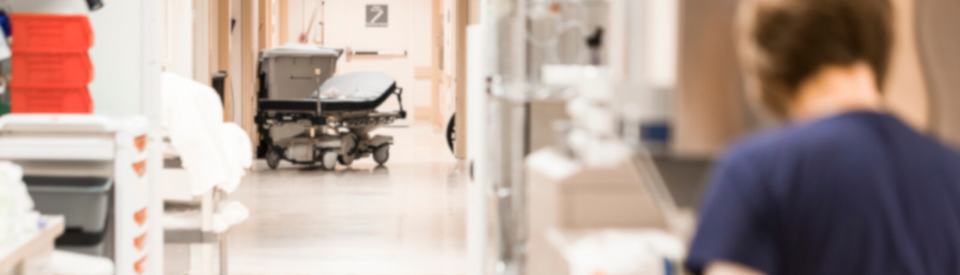 A nurse walks down the hospital hallway.