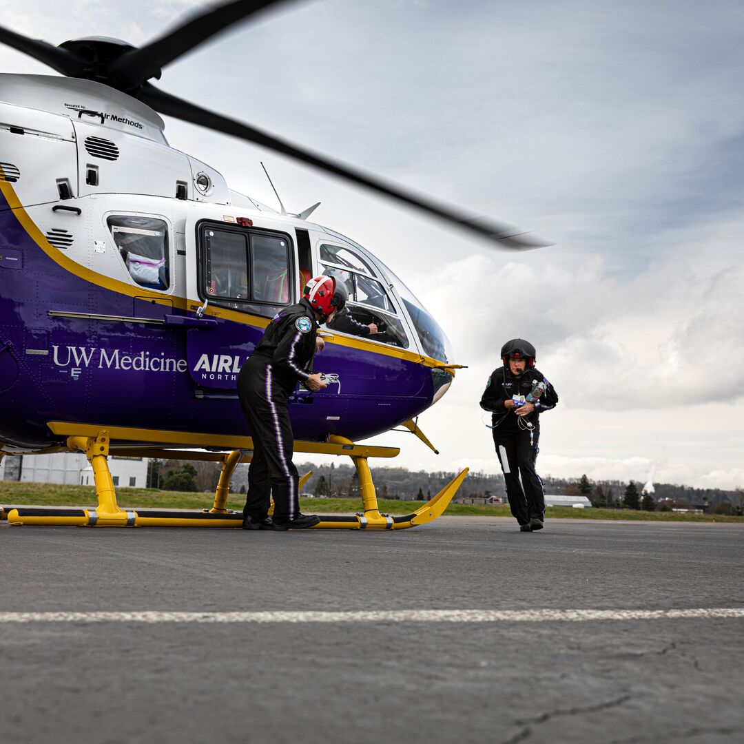 An Airlift NW nurse runs next to the helicopter.