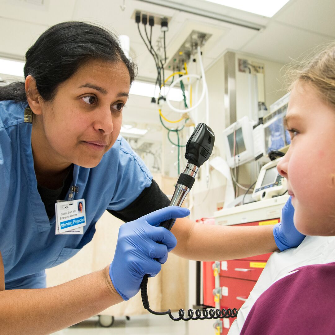 Dr. Sachita Shaw looks at the eyes of a patient.