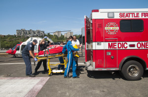 Paramedics pull a patient on a stretcher