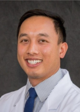 Headshot of Anthony Le against a gray textured background