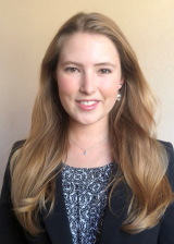 Headshot of Alayna Barela standing against a light orange background