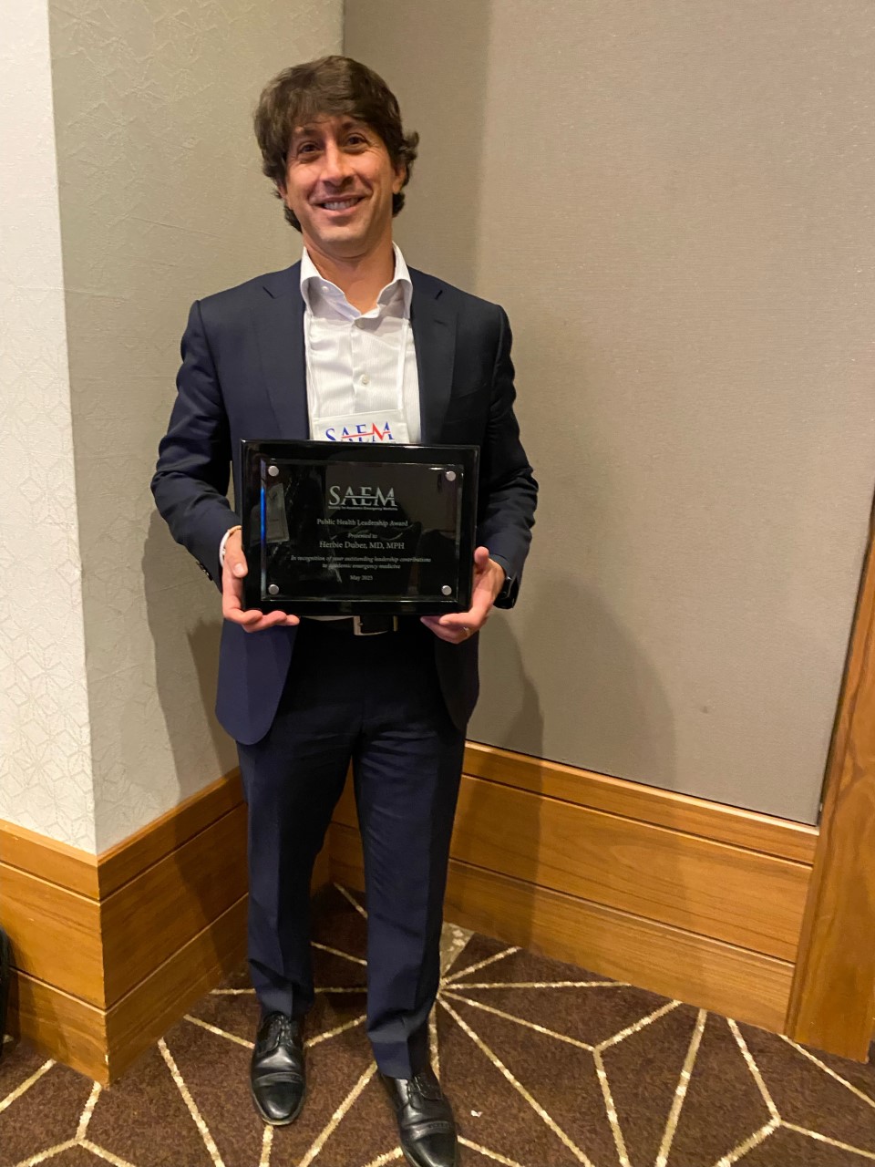 Dr. Duber holds his award plaque.