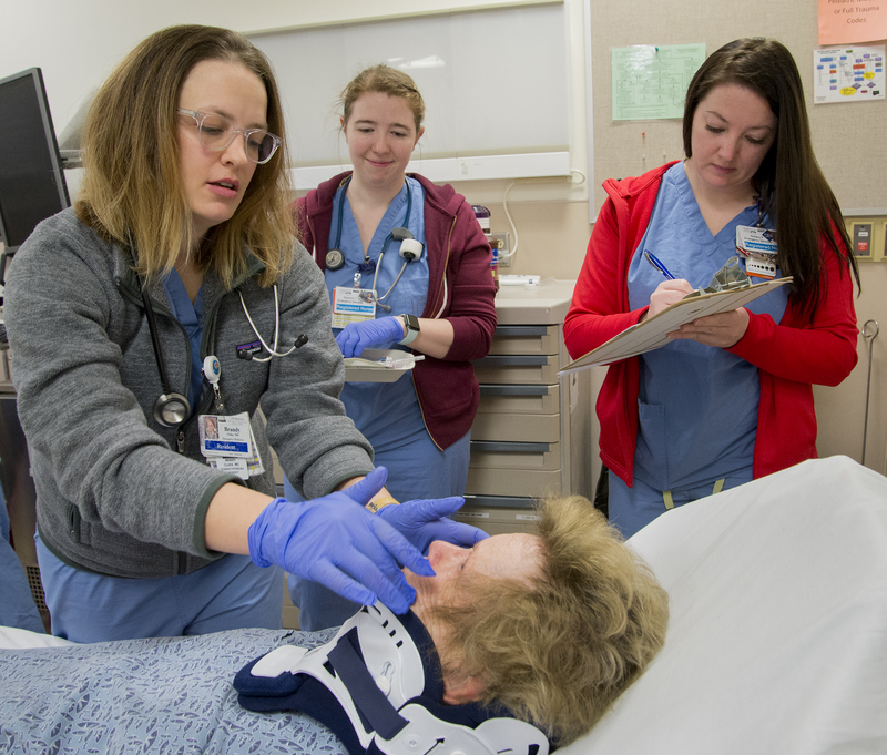 Medical students observe an ER physician. 