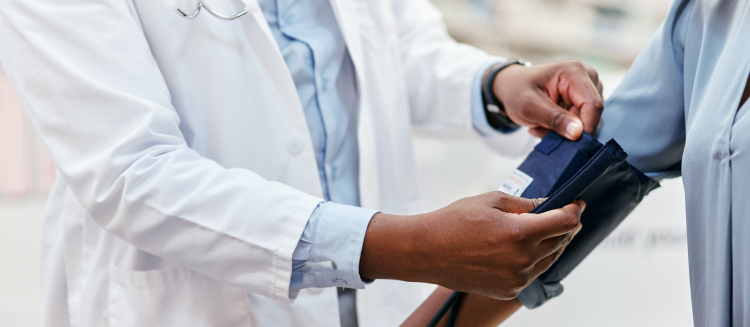 Stock photo of doctor taking a patients blood pressure with a blood pressure cuff.