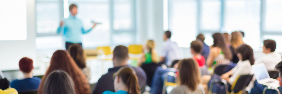 Stock photo of a man presenting to a room full of people
