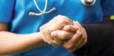 A doctor holds the hand of a patient